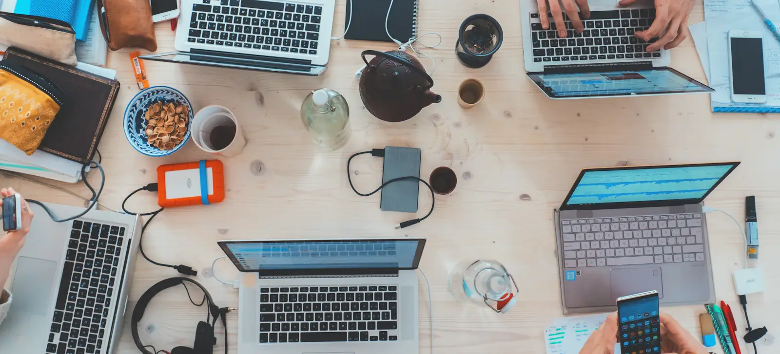 Arbeitsplatz von oben mit mehreren Laptops und Notizen
